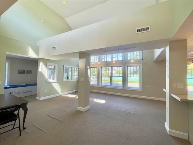 living room featuring carpet floors and a towering ceiling