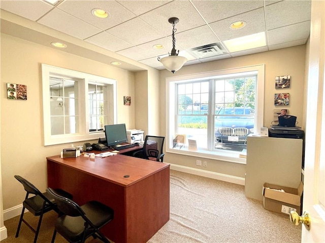 carpeted office with a paneled ceiling