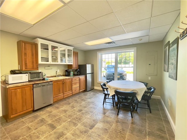 kitchen with a paneled ceiling, sink, stainless steel appliances, and electric panel