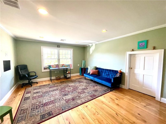 living area featuring wood-type flooring and ornamental molding