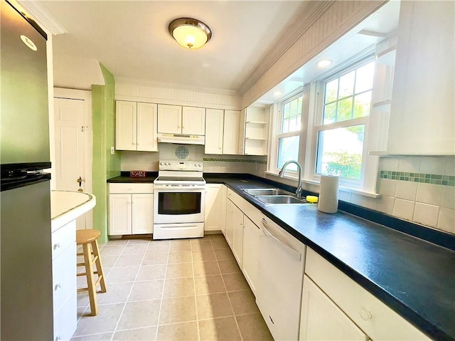 kitchen featuring sink, light tile patterned floors, tasteful backsplash, white appliances, and white cabinets