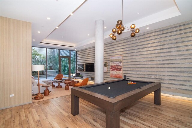 playroom with a raised ceiling, expansive windows, light hardwood / wood-style floors, and pool table