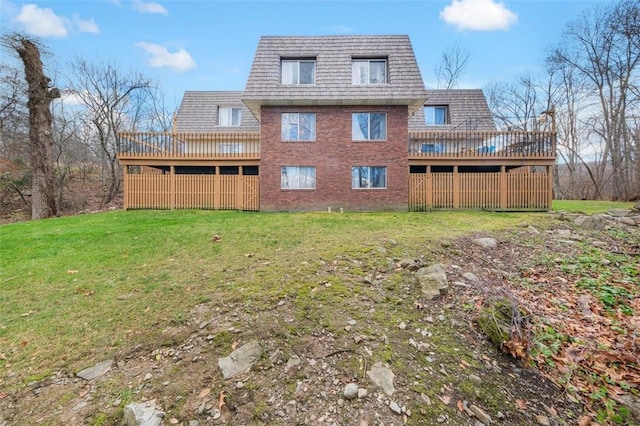 back of property featuring a lawn and a wooden deck