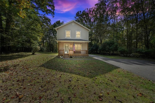 view of front facade featuring covered porch and a yard