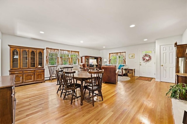 dining space with baseboard heating and light hardwood / wood-style flooring