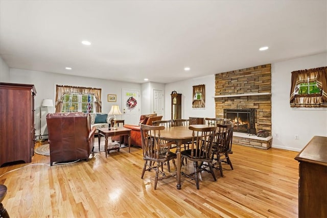 dining area with a fireplace and light hardwood / wood-style floors