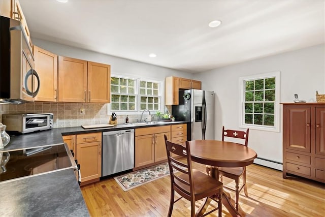 kitchen featuring a healthy amount of sunlight, sink, stainless steel appliances, and light hardwood / wood-style flooring