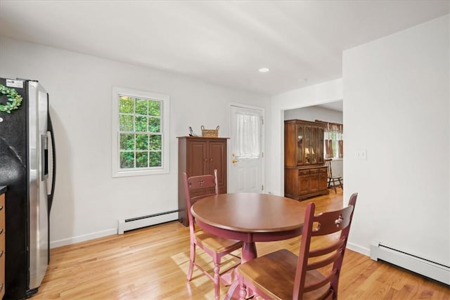 dining room with light hardwood / wood-style flooring and a baseboard heating unit