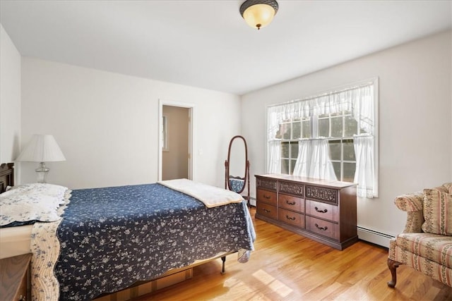 bedroom featuring light wood-type flooring and baseboard heating