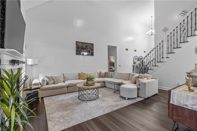 living room featuring dark hardwood / wood-style flooring, high vaulted ceiling, and a chandelier