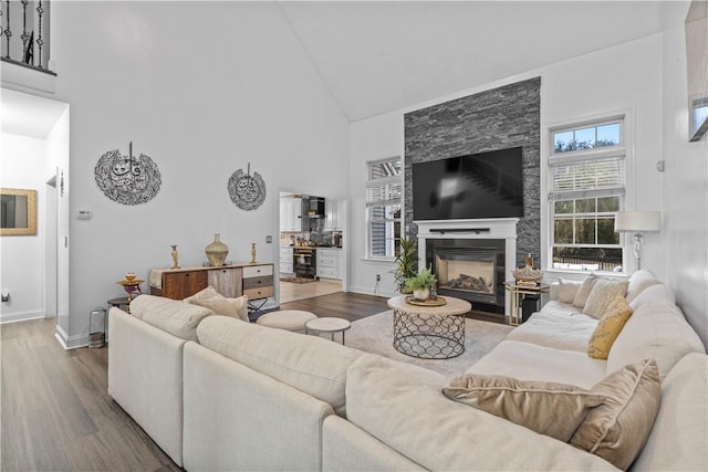 living room with hardwood / wood-style floors, a fireplace, and high vaulted ceiling