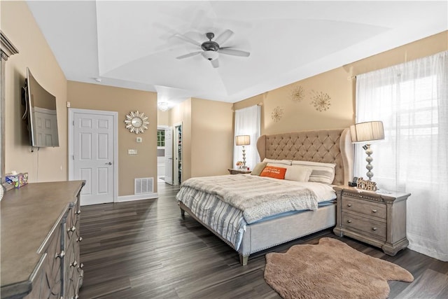 bedroom featuring a raised ceiling, ceiling fan, dark hardwood / wood-style flooring, and vaulted ceiling