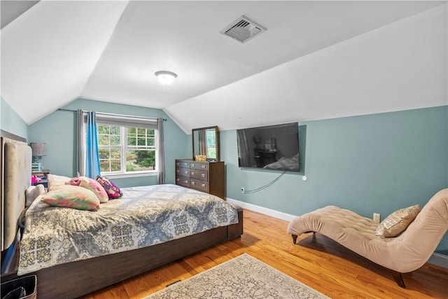 bedroom featuring lofted ceiling and light wood-type flooring