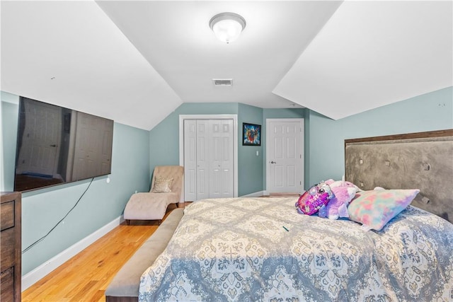 bedroom with hardwood / wood-style floors and lofted ceiling