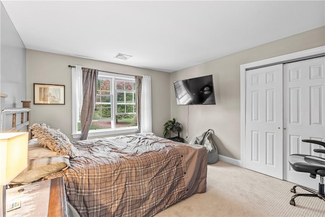 bedroom with light carpet and a closet