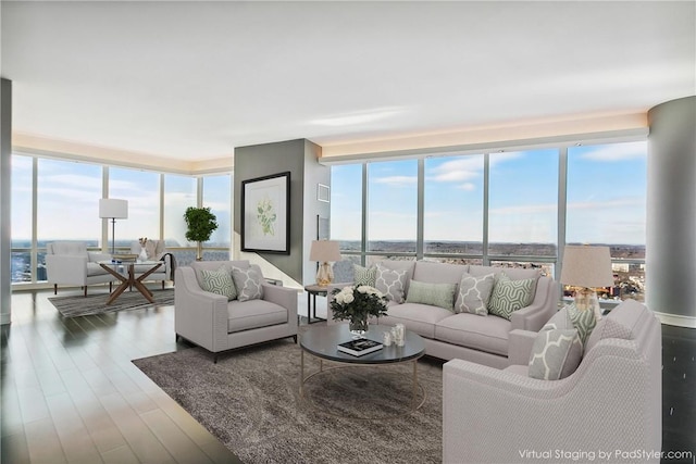 living room featuring floor to ceiling windows, a healthy amount of sunlight, and hardwood / wood-style flooring