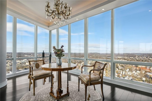 sunroom / solarium featuring a notable chandelier