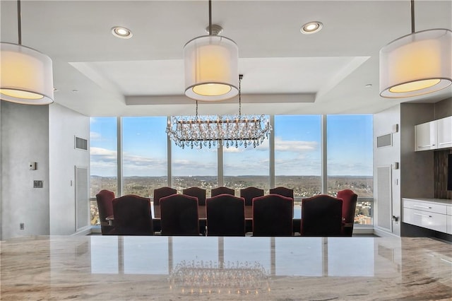 dining space featuring a chandelier, a tray ceiling, and plenty of natural light