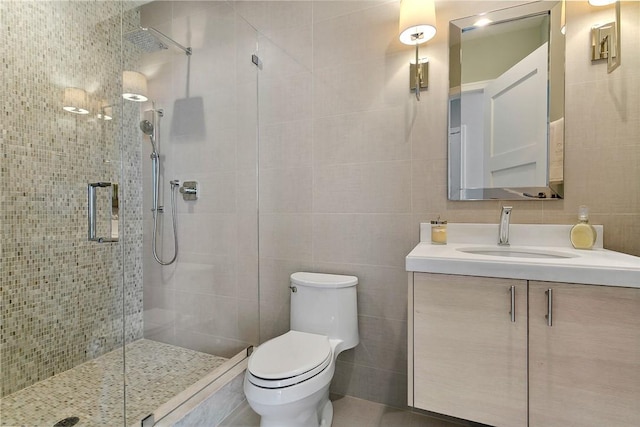 bathroom featuring an enclosed shower, vanity, toilet, and tile walls