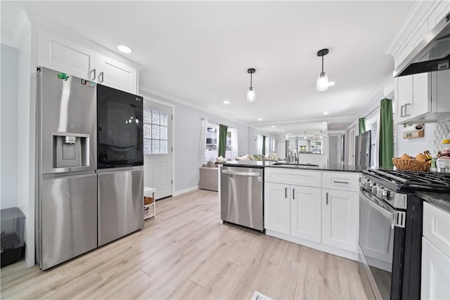 kitchen with white cabinetry, wall chimney exhaust hood, stainless steel appliances, light hardwood / wood-style floors, and decorative light fixtures