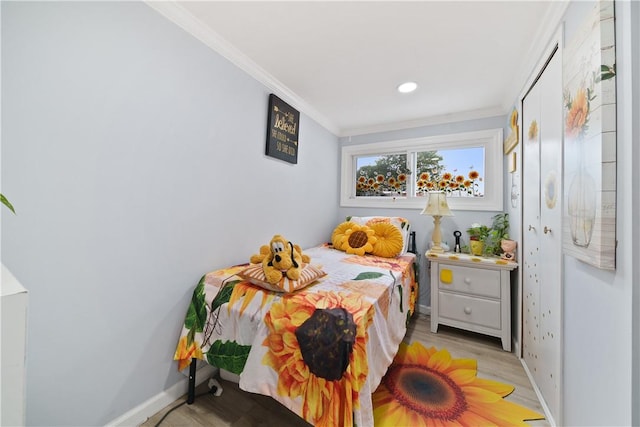 bedroom with light wood-type flooring and crown molding