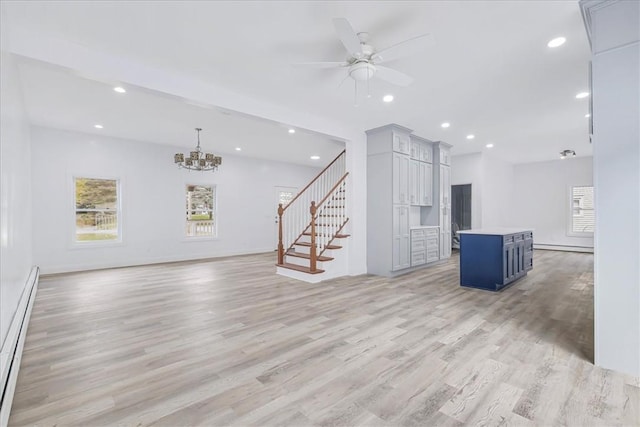 unfurnished living room with ceiling fan with notable chandelier, light hardwood / wood-style floors, and a baseboard radiator