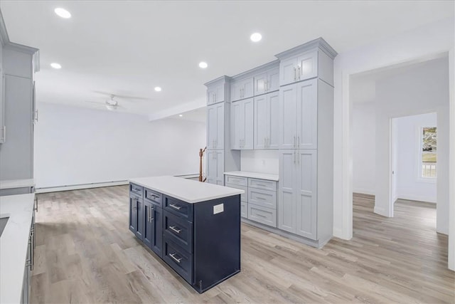 kitchen with ceiling fan, light hardwood / wood-style floors, and a kitchen island