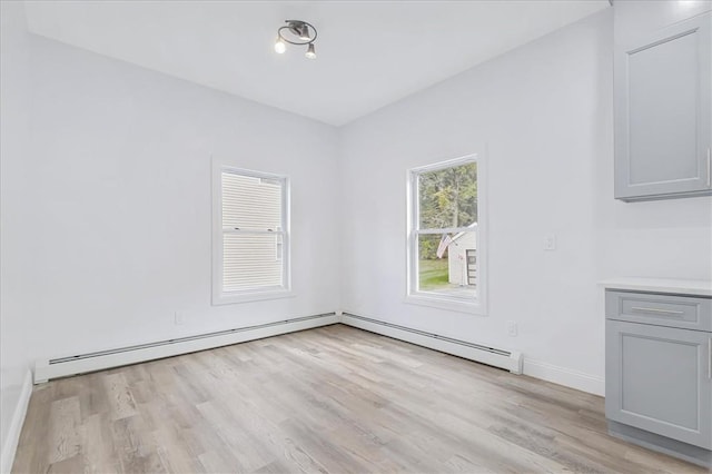 empty room featuring light hardwood / wood-style floors and baseboard heating