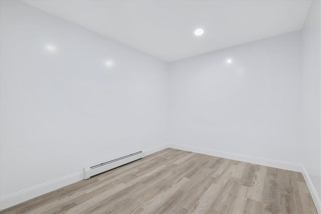 empty room featuring light hardwood / wood-style flooring and a baseboard heating unit