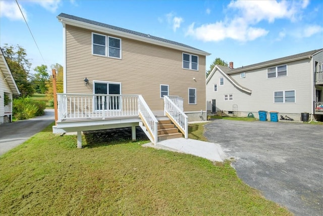 back of house with a lawn and a deck