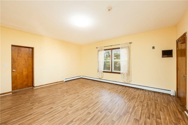 unfurnished room with a baseboard radiator and light hardwood / wood-style flooring