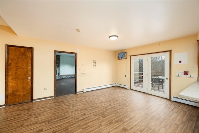 spare room featuring french doors, hardwood / wood-style flooring, and a baseboard radiator