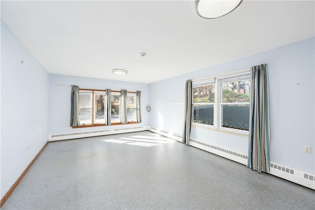 empty room featuring a baseboard radiator and a healthy amount of sunlight