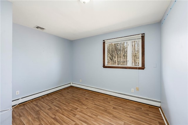 spare room with light wood-type flooring and baseboard heating