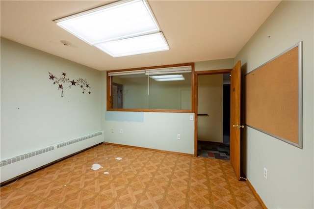 unfurnished room featuring parquet flooring and a baseboard heating unit