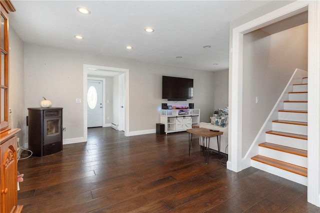 living room featuring dark hardwood / wood-style floors and a wood stove