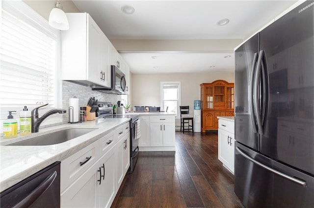 kitchen featuring sink, white cabinets, pendant lighting, and appliances with stainless steel finishes