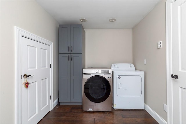 laundry area featuring cabinets, dark wood-type flooring, and washing machine and clothes dryer