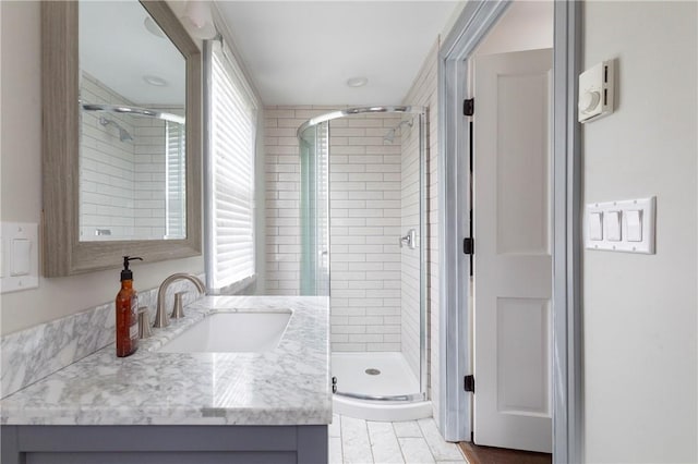 bathroom featuring plenty of natural light, vanity, and walk in shower