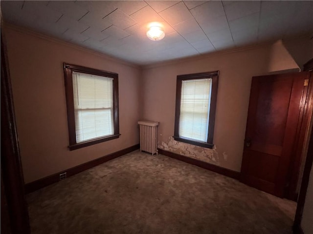 unfurnished bedroom featuring carpet flooring, radiator heating unit, multiple windows, and crown molding