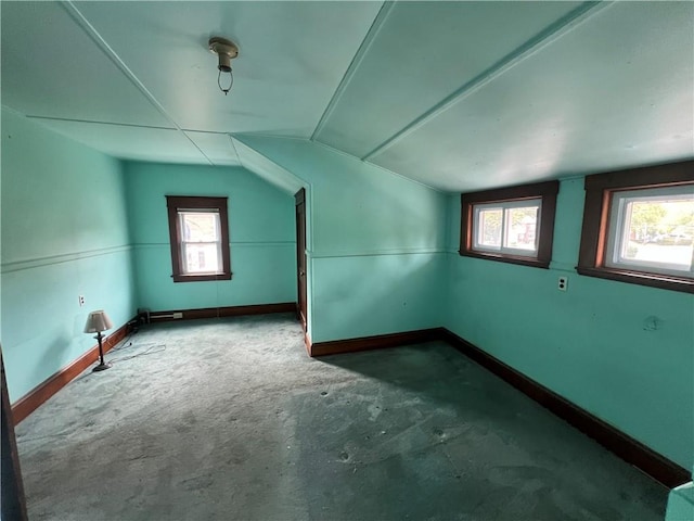 additional living space with concrete flooring and lofted ceiling