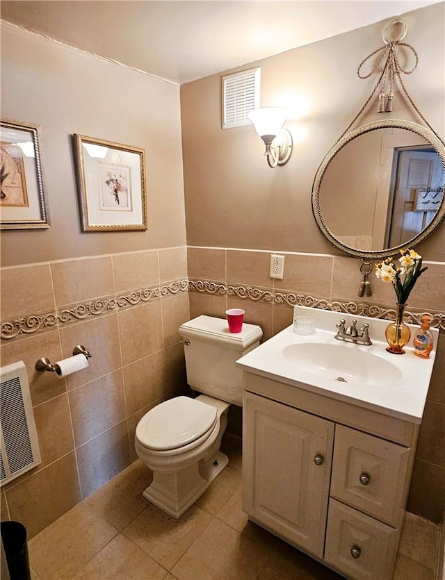 bathroom with tile patterned floors, vanity, tile walls, and toilet