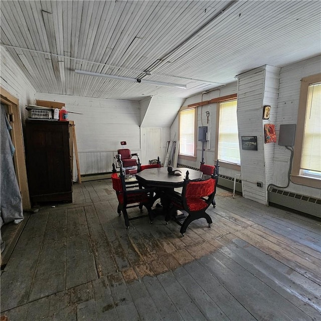 dining area featuring wooden walls, dark wood-type flooring, and vaulted ceiling