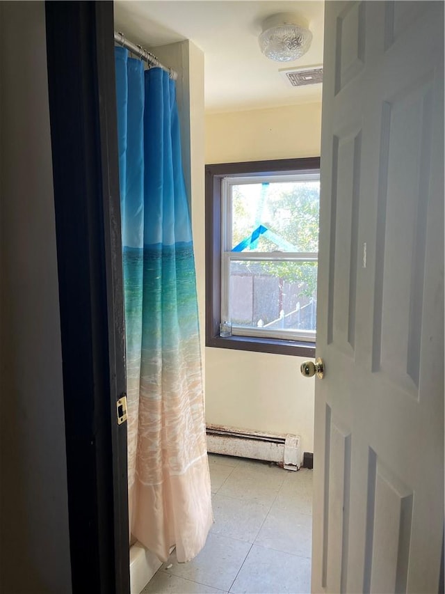 bathroom featuring a shower with shower curtain, tile patterned floors, and baseboard heating