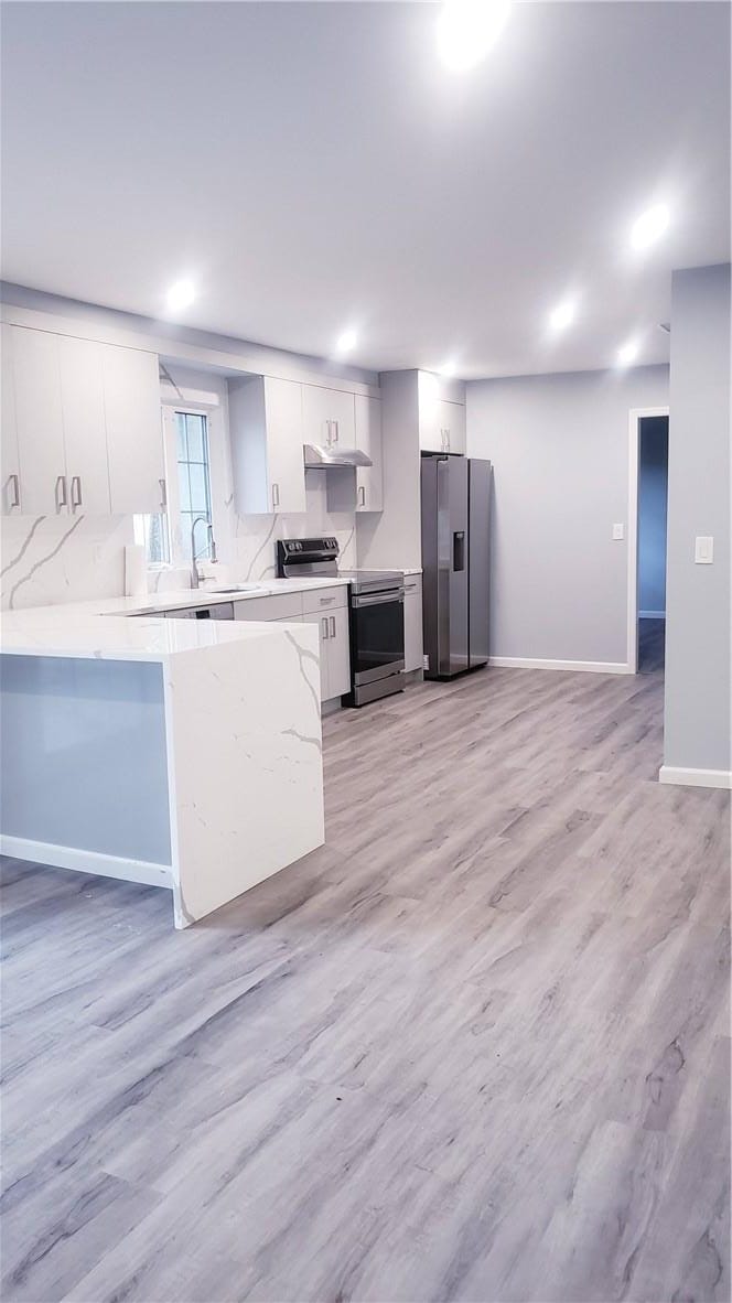 kitchen with white cabinetry and tile walls