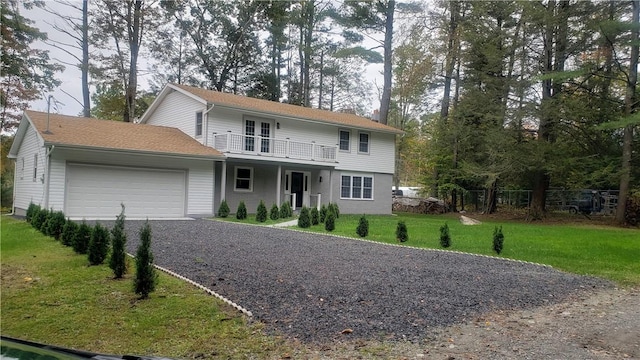 view of front property featuring a balcony, a front lawn, and a garage