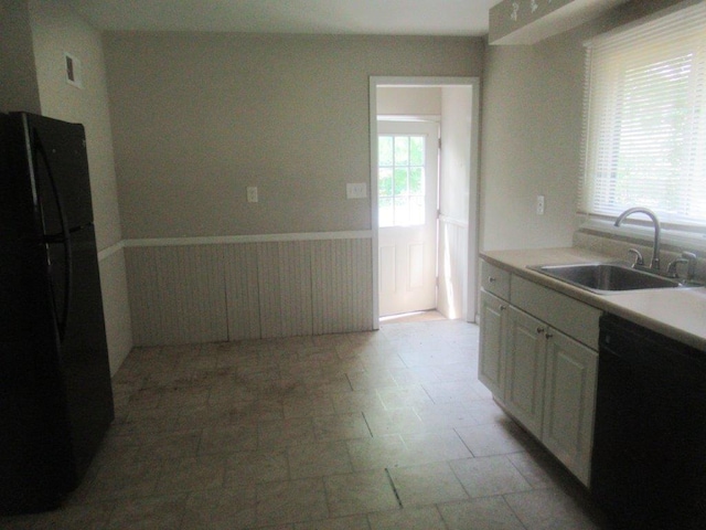 kitchen featuring sink, white cabinets, and black appliances