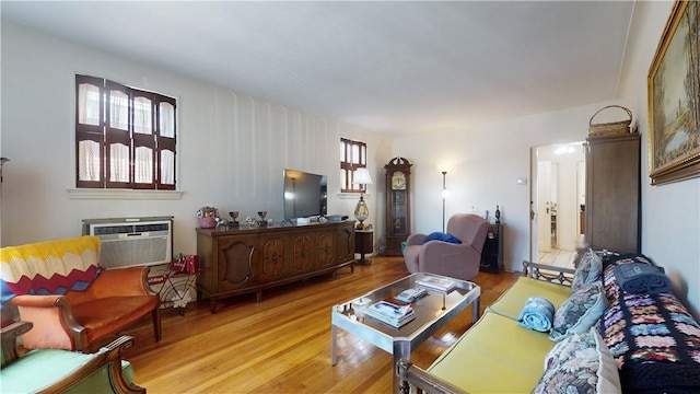 living room with light wood-type flooring and a wall unit AC