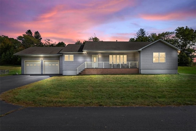 ranch-style house featuring a garage and a lawn