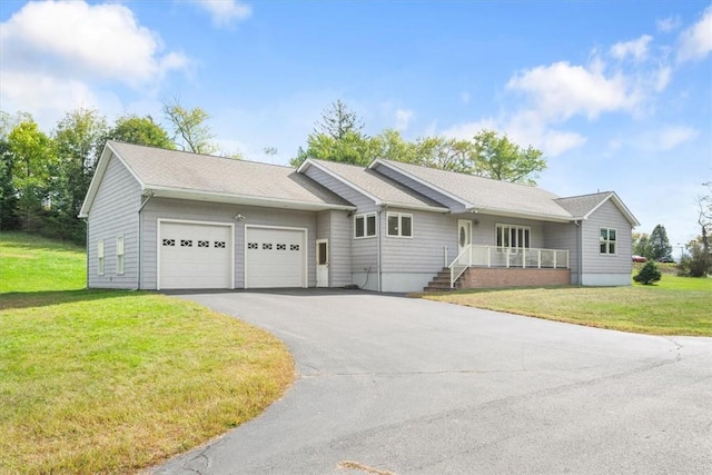 single story home with a porch, a garage, and a front lawn